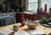 Books That Explore the Power of Food and Memory "cluttered Queens kitchen table with mismatched chairs"