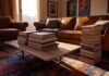 Coffee Table Fashion Books That Double as Decor (My Actual Favorites) A high-res photo of a cozy Queens NYC living room with a worn leather sofa, a funky patterned rug